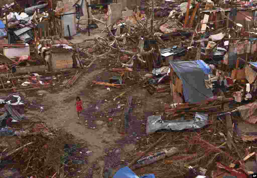 A young girl walks amid ruins of houses in a neighborhood badly affected by Typhoon Haiyan in Guiuan, Philippines, Nov. 15, 2013.