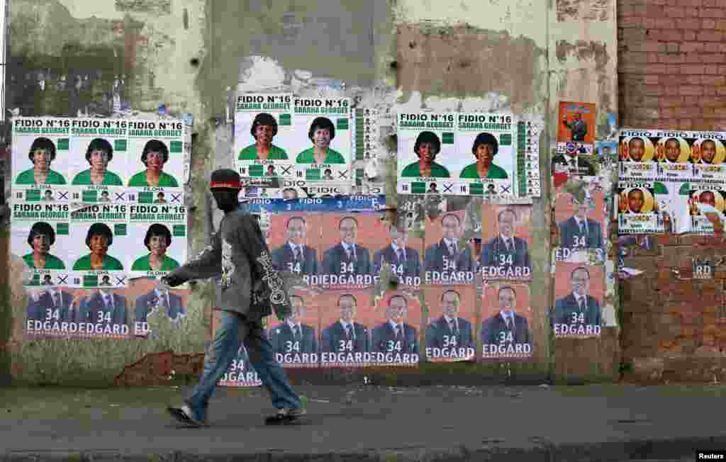 A man walks past campaign posters outside a polling center in Antananarivo, Madagascar, Oct. 25, 2013.