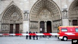 Police officers stand guard in front of Notre Dame Cathedral, in Paris, Tuesday, May 21, 2013. Notre Dame has been evacuated after a man committed suicide in the 850-year-old monument and tourist attraction. (AP Photo/Thibault Camus)