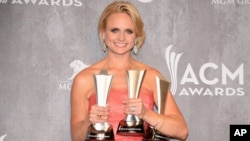 Miranda Lambert poses in the press room with the awards for Vocal Event of the Year, Female Vocalist of the Year and Single Record of the Year at the 49th annual Academy of Country Music Awards at the MGM Grand Garden Arena in Las Vegas, April 6, 2014.