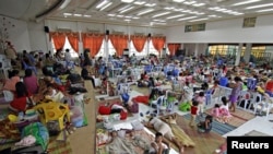People take shelter inside a evacuation centre after evacuating from their homes due to super-typhoon Hagupit in Surigao city, southern Philippines, Dec. 5, 2014.