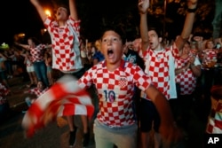 Bosnian Croats, in the streets of the southern-Bosnian town of Mostar, cheer while watching the quarterfinal match of the FIFA 2018 World Championship between Croatia and Russia, in Mostar, July. 7, 2018. The Croatian national team won the match and advan