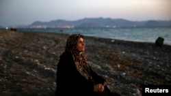 逃离叙利亚的70岁巴勒斯坦盲人难民阿穆在抵达希腊科斯岛后在海滩上歇息。8月12日她与其他40人搭乘小艇从土耳其越过爱琴海抵达希腊。
