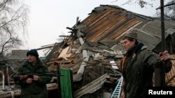 Проросійський повстанець і місцевий житель стоять біля зруйнованоо будинку, Горлівка, 14 грудня 2014 р.