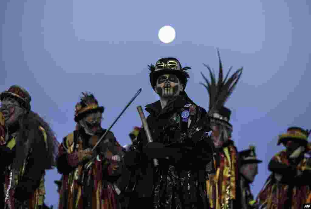 Members of the Powderkeg Morris Dancers climb down after dancing atop the Windgather Rocks at High Peak in Derbyshire, Britain, before sunrise. The Powderkeg Morris dancers perform an annual dance atop the Windgather Rocks at sunrise, as part of an ancient Celtic festival celebrated on May Day or the beginning of summer.