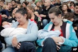 FILE - Mothers breast-feed their babies in Paris, Oct. 11, 2008, during a worldwide breast-feeding event.