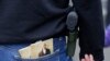 Une femme porte une arme en même temps que deux exemplaires de la Constitution américaine lors d’un meeting pro-armes à Olympia, dans l’État de Washington.