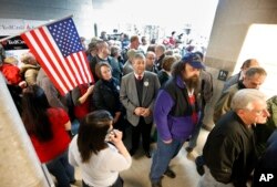 An overflow crowd waits to get into the gymnasium at Chelsea Elementary School to cast their votes at a Republican caucus in Chelsea, Maine, March 5, 2016.