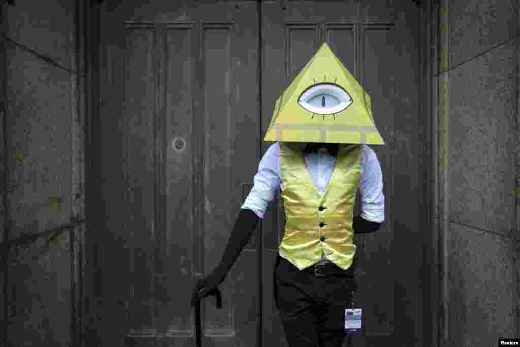 Max Louscher dressed as Bill Cipher from Gravity Falls poses as he attends Day 2 of New York Comic Con in Manhattan. The event draws thousands of costumed fans, panels of pop culture luminaries and features a sprawling floor of vendors in a space equivalent to more than three football fields at the Jacob Javits Convention Center.