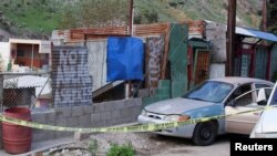 The body of Mexican photojournalist Margarito Martinez Esquivel (obscured) lies on the ground next to his car after he was killed outside his home, in Tijuana, Mexico, Jan. 17, 2022.
