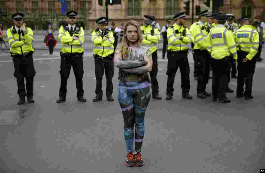 یک معترض به بی توجهی به تغییرات آب و هوایی در مقابل پلیس در شهر لندن. چند روزی است که معترضان با شعار &laquo;شورش علیه انقراض&raquo; نافرمانی مدنی کرده اند.&nbsp;
