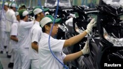 Para pekerja merakit sepeda motor di pabrik PT Astra Honda Motor di Cikarang. 