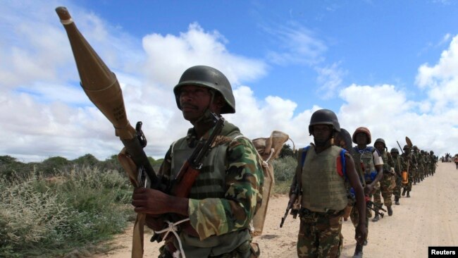 FILE - African Union Mission in Somalia (AMISOM) peacekeepers from Burundi patrol after fighting between insurgents and government soldiers on the outskirts of Mogadishu, May 22, 2012.