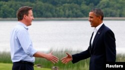 Britain's Prime Minister David Cameron (L) welcomes U.S. President Barack Obama on his arrival to the Lough Erne golf resort where the G8 summit is taking place in Enniskillen, Northern Ireland, June 17, 2013.