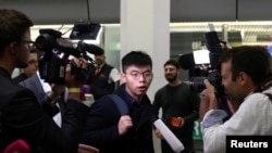 Hong Kong's pro-democracy activist Joshua Wong is surrounded by journalists after arriving at Tegel Airport in Berlin, Germany, Sept. 9, 2019. 