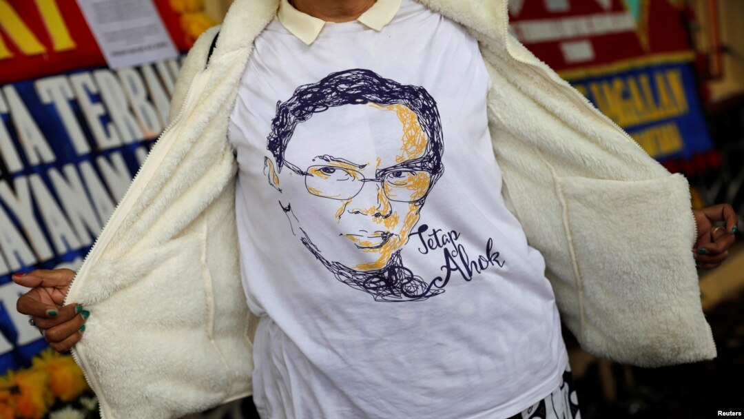 Seorang pendukung mantan gubernur Jakarta, Basuki "Ahok" Tjahaja Purnama, mengenakan t-shirt dengan gambar Ahok dekat markas Brimob di Depok, 24 Januari 2019.