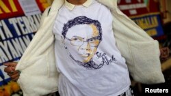 Seorang pendukung mantan gubernur Jakarta, Basuki "Ahok" Tjahaja Purnama, mengenakan t-shirt dengan gambar Ahok dekat markas Brimob di Depok, 24 Januari 2019.