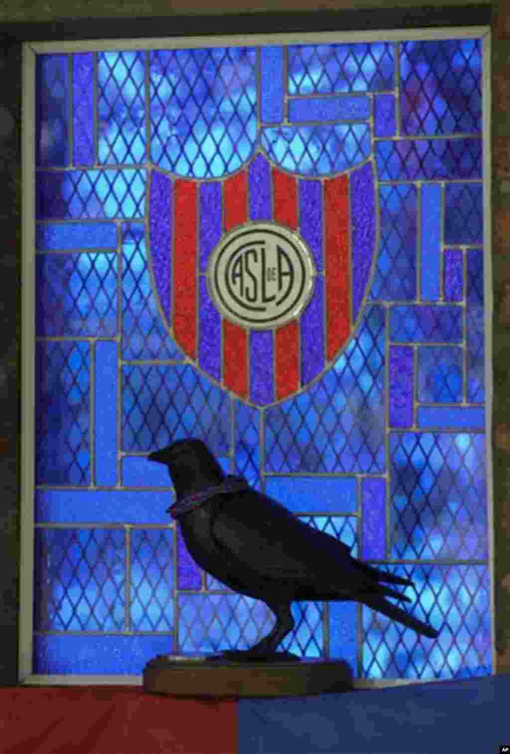 A statue of a crow is silhouetted against the San Lorenzo de Almagro chapel window in Buenos Aires, Argentina, Thursday, March 14, 2013. The San Lorenzo soccer team is sometimes called the &quot;Crows,&quot; after the black color of a priest&#39;s robe.