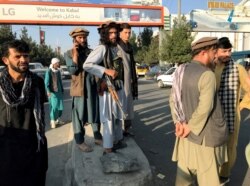 A member of Taliban, center, stands outside Hamid Karzai International Airport in Kabul, Afghanistan, August 16, 2021.
