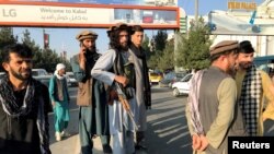 A member of Taliban, center, stands outside Hamid Karzai International Airport in Kabul, Afghanistan, August 16, 2021. 