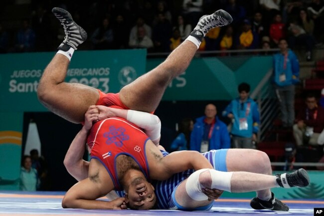 Catriel Muriel de Argentina, derecha, pelea contra Donovan Smith de Cuba en el partido por la medalla de bronce de lucha libre masculina de 125 kg en los Juegos Panamericanos de Santiago, Chile, el miércoles 1 de noviembre de 2023.