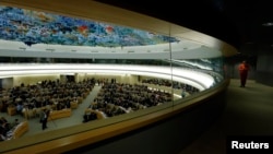 FILE - A staff member walks along a corridor during the 26th session of the Human Rights Council at the United Nations in Geneva, Switzerland, June 10, 2014. 