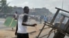 A man holds a machete while angry residents burn tires and block the street where security forces loyal to Ivory Coast's strongman, Laurent Gbagbo, opened fire on demonstrators, killing at least six women, on March 3, 2011 in Abobo, a working class neighb