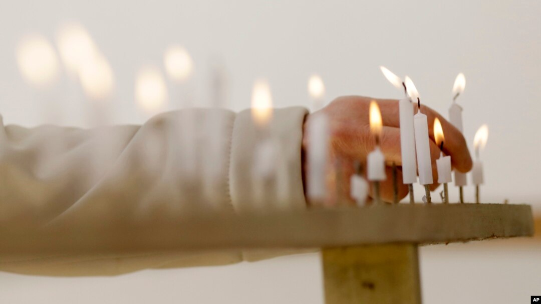 A woman lights a candle to mourn for victims of the March 11, 2011 earthquake and tsunami before a special memorial event in Tokyo, March 11, 2017. Japan marked the sixth anniversary of the 2011 disaster that left more than 18,000 people dead or missing and led to a meltdown at the Fukushima Dai-Ichi nuclear plant.