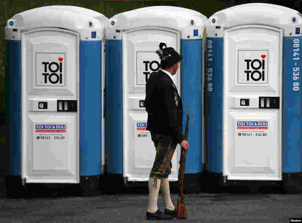 A Bavarian mountain rifleman in a traditional outfit stands in front of portable toilets as he attends a parade in the southern village of Miesbach, Germany. About 5,000 mountaineers from Bavaria joined the traditional annual parade to honour Patron Bavariae, the Patron of Bavarian mountain rifleman.