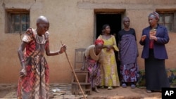 Prudencienne Namukobwa, 85, left, entertains her guests with akazehe, a Burundian traditional form of musical greeting performed exclusively by women, outside her house in Ngozi, Burundi, Sept. 20, 2024. 