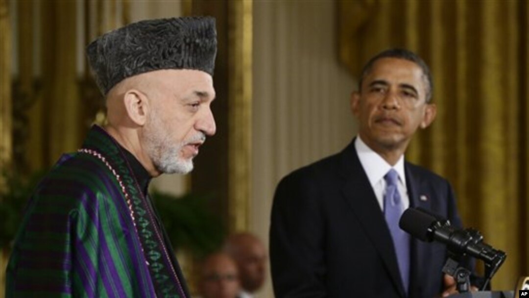 Presiden Barack Obama mendengarkan Presiden Hamid Karzai yang tengah memberikan penjelasan dalam konferensi pers di Gedung Putih, Jumat (11/1).