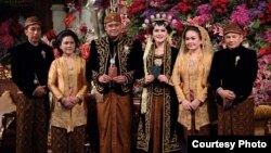 Presiden Indonesia Joko Widodo (kiri) dan Ibu Negara Iriana Widodo (dua dari kiri) berpose dengan putri mereka Kahiyang Ayu dan menantu Bobby Nasution (tiga dari kanan), bersama ibunya Hanifah Siregar dan paman Irwin Nasution (R) saat berlangsungnya upacara pernikahan di Solo, Jawa Tengah, 8 November 2017.