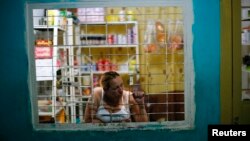 Una mujer cuida su tienda dentro de un edificio en Caracas.