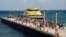FILE - Tourists and passengers disembark from a ferry onto the wharf on Playa del Carmen, Mexico, March 2, 2018. The U.S. Embassy in Mexico has narrowed its travel warning for the city amid what it calls an unspecified security threat. 