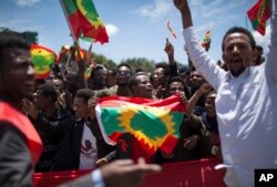 FILE —In this September 15, 2018 photo, a man holds an Oromo Liberation Front (OLF) flag as hundreds of thousands of Ethiopians gathered to welcome returning leaders of the once-banned group in the capital Addis Ababa, Ethiopia.