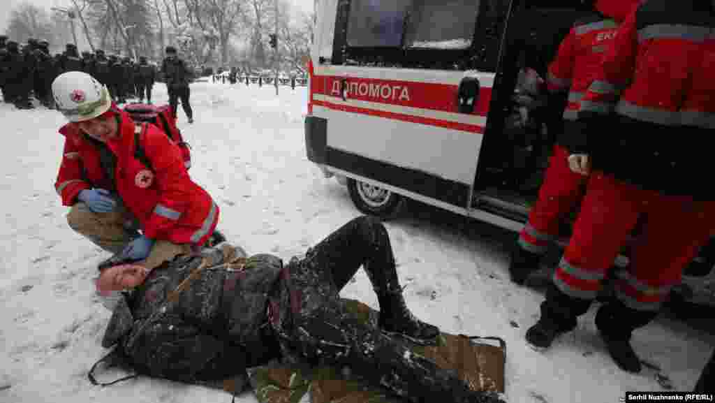 A paramedic gives the first aid to an protester injured in a clash between riot police and supporters of Mikheil Saakashvili in a tent camp in Kyiv, Ukraine, March 3, 2018.