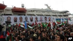 FILE - People holding Turkish and Palestinian flags cheer as the Mavi Marmara ship, in the background, the lead boat of a flotilla headed to the Gaza Strip which was stormed by Israeli naval commandos in the Mediterranean May 31, 2010, returns to Istanbul, Turkey.