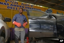 A mechanic stands at Nas auto solution electric vehicle workshop in Addis Ababa, Oct. 3, 2024.