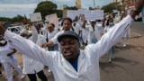 Membros da comunidade médica moçambicana marcham em direção à estátua Eduardo Mondlane em protesto contra a violação dos direitos humanos 