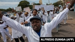 Membros da comunidade médica moçambicana marcham em direção à estátua Eduardo Mondlane em protesto contra a violação dos direitos humanos 