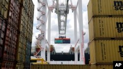 FILE - A crane removes a container from a ship at the Port of Baltimore's Seagirt Marine Terminal in Baltimore, Maryland.