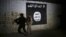 Un soldat irakien inspecte un tunnel orné d'un drapeau du groupe État islamique le 1er mars 2017.
