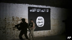 Иракский солдат осматривает туннель, на стене которого висит флаг группировки "Исламское государство" (архивное фото)