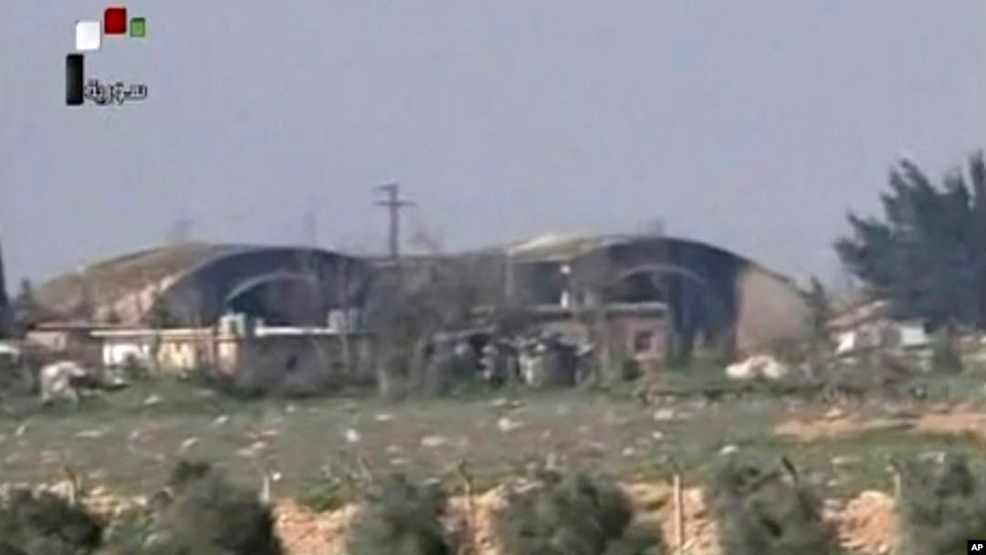 FILE - This frame grab from video provided April, 7, 2017, by official Syrian TV shows the burned and damaged hangars hit by U.S. Tomahawk missiles at the Shayrat air base southeast of Homs, Syria.