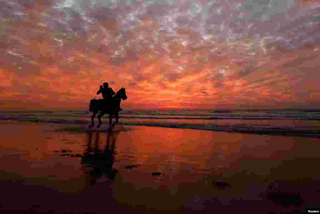 A Palestinian man rides a horse on a beach, in Gaza City.