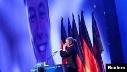 Alice Weidel, co-leader of the Alternative for Germany party (AfD), applauds as U.S. tech CEO Elon Musk appears via video link at a central election campaign event in Halle, Germany, Jan. 25, 2025.