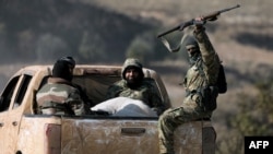 Anti-government fighters ride in the back of a pickup in the town of Suran, between Aleppo and Hama, Dec. 3, 2024.