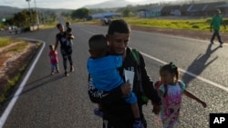 Venezuelan Miguel Gonzalez and his family walk to transportation that will take them to the Brazilian border, in Santa Elena, Venezuela, April 5, 2023.