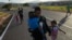 Venezuelan Miguel Gonzalez and his family walk to transportation that will take them to the Brazilian border, in Santa Elena, Venezuela, April 5, 2023.