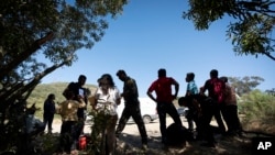 ARCHIVO - Agentes de la Patrulla Fronteriza hablan con migrantes que buscan asilo mientras los preparan para el transporte para ser procesados, el 5 de junio de 2024, cerca de Dulzura, California. AP